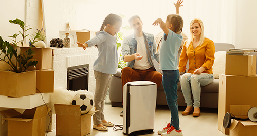 Family around air purifier with moving boxes