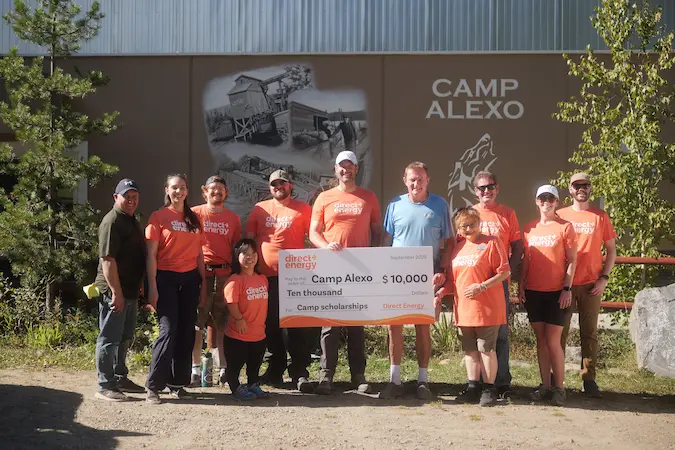 Camp Alexo staff and volunteers proudly display a $10,000 cheque, celebrating their fundraising efforts together.