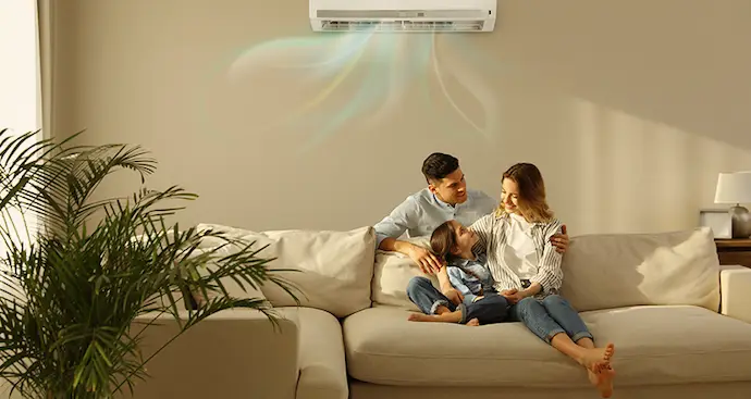 A family enjoys time together on a couch with a fan providing a cool breeze.
