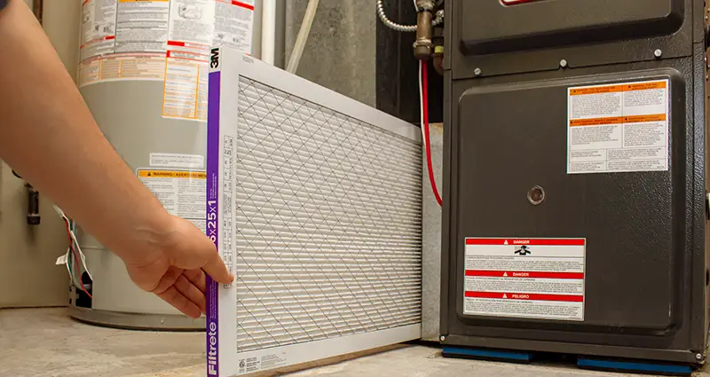 Man replacing furnace filter