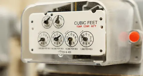 Close-up of a meter displaying readings, with a sign attached indicating its purpose or usage instructions.