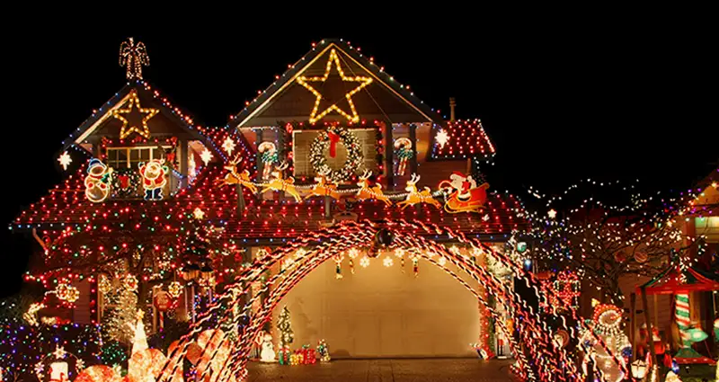 A house adorned with colorful Christmas lights and festive decorations, creating a cheerful holiday atmosphere.