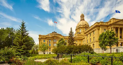 A large building featuring a prominent tower and a flag pole at its peak.