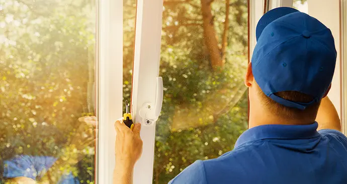 Man installing window, indoors. 