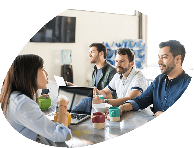group of people working around a laptop