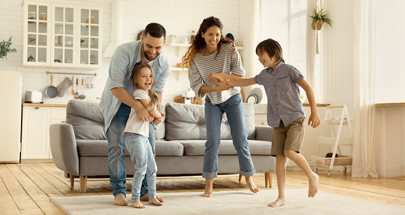 Family of four dancing and laughing