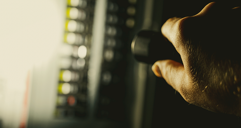 Hand with flightlight shining an electrical panel