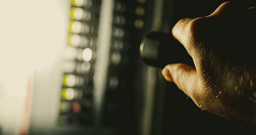 Hand with flightlight shining an electrical panel