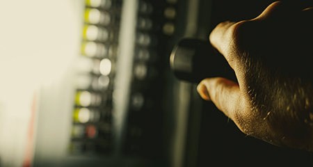 Hand with flightlight shining an electrical panel