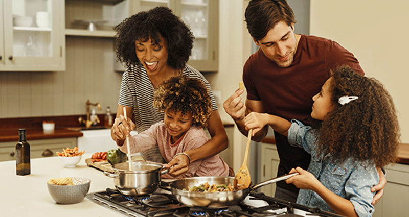 Family of four cooking over a natural gas stove