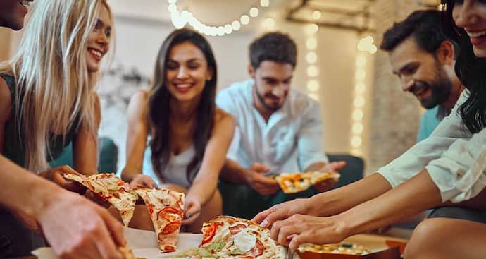 Friends at party eating pizza