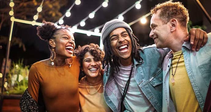 Four friends side by side laughing