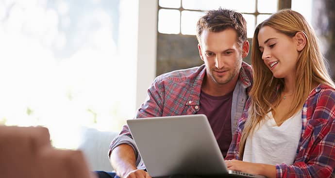 Couple sitting while using a laptop