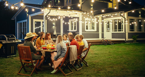 Family and friends enjoying an evening eating dinner in the backyard