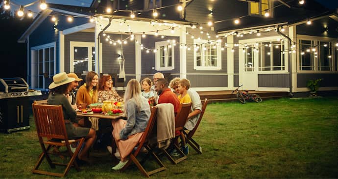 family and friends enjoying an evening eating dinner in the backyard