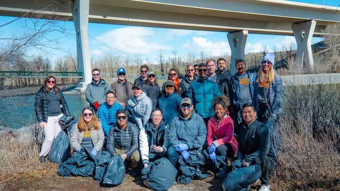A group of people smiling for a photo in front of a bridge.
