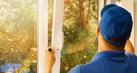 Man in baseball hat installing new window