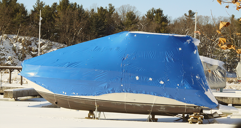 Boat covered with blue tarp for winter