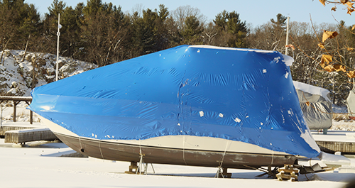 Boat covered with blue tarp for winter