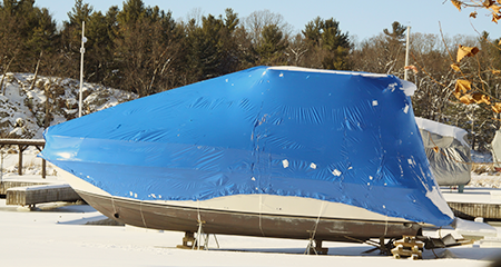 Boat covered with blue tarp for winter