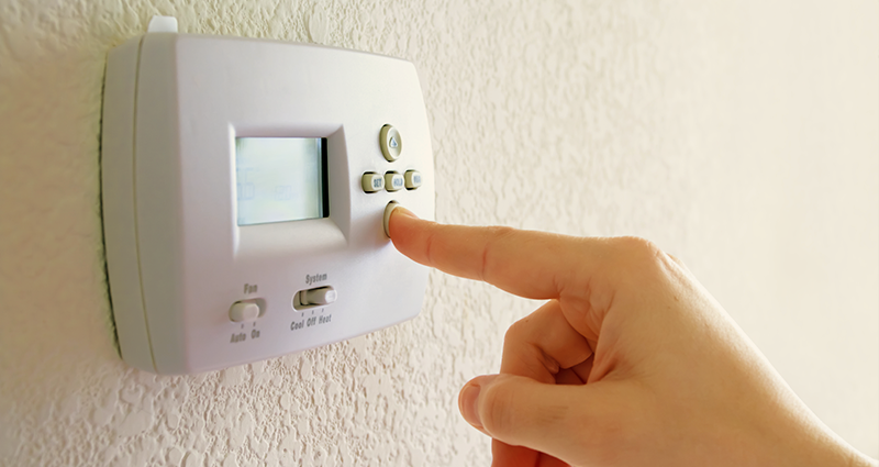 Person adjusting home thermostat