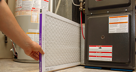 Man replacing furnace filter