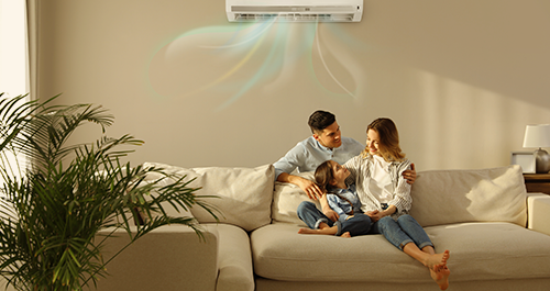 Family of three sitting under portable air conditioning unit
