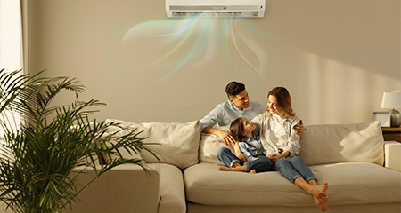 Family of three sitting under portable air conditioning unit