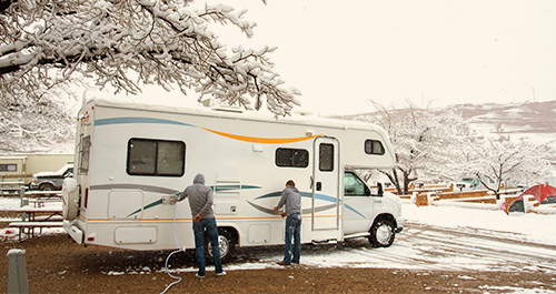 Two people winterizing their motorhome