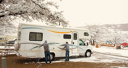 Two people winterizing their motorhome
