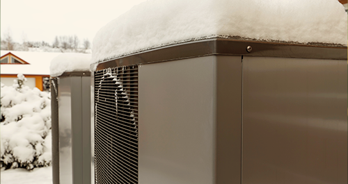 Heat pump covered in snow