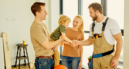 Family with young boy shaking hands with contractor