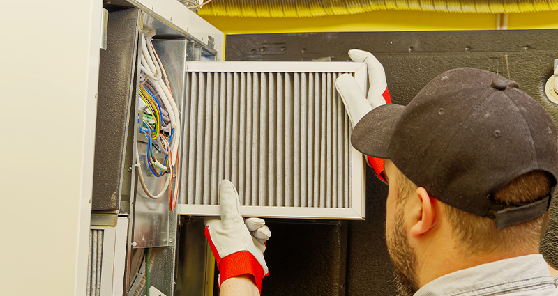 Contractor inspecting furnace filter