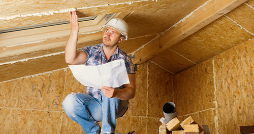 Contractor inspecting house interior roof line