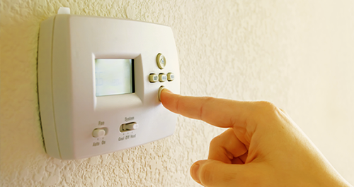 Person adjusting home thermostat