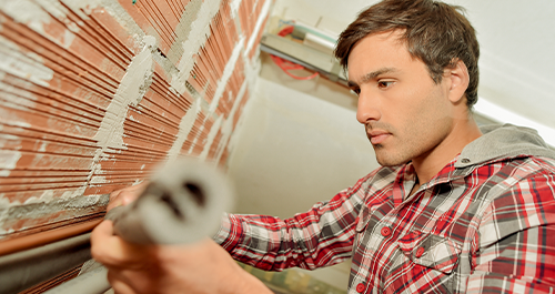 Man inspecting pipes and plumbing for winter