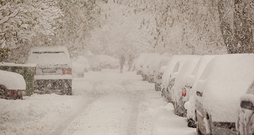 Image of street lined snow-covered cars