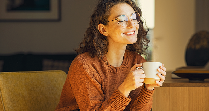 Young woman smiling with mug in hand