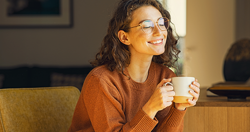 Young woman smiling with mug in hand