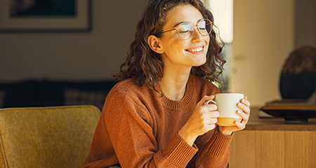 Young woman smiling with mug in hand