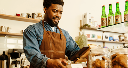 Young African America male cafe owner working at till