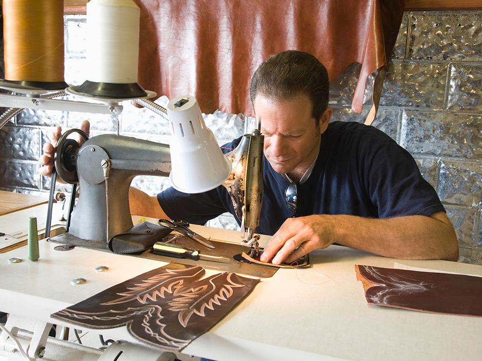 Male leather boot maker at sewing machine