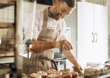 man smiling while baking in professional kitchen